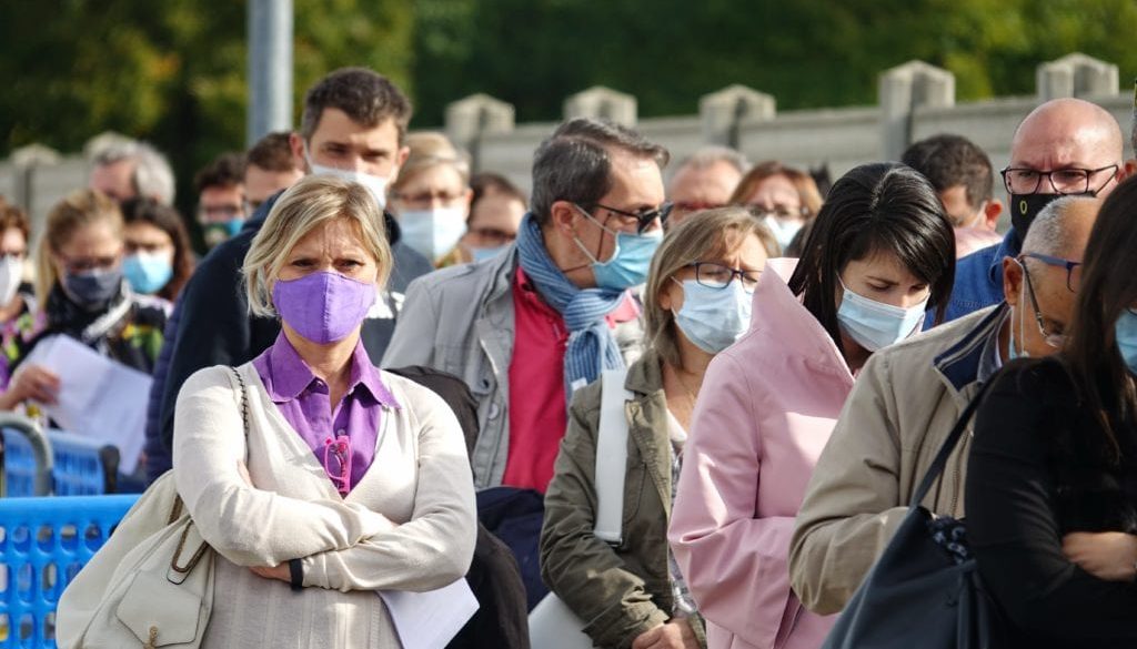 masked crowd waiting in line for vaccine